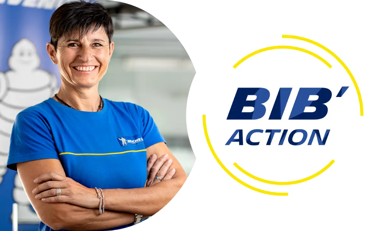 BIB Action. A woman wearing a blue Michelin uniform. She has dark hair, her arms are crossed and she's is smiling. 