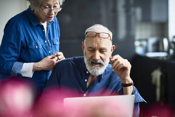 elderly couple looking at laptop