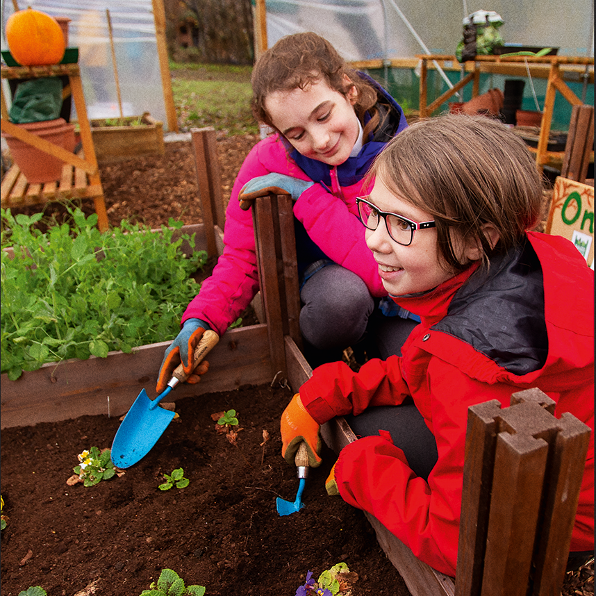children planting plants in a greenhouse
