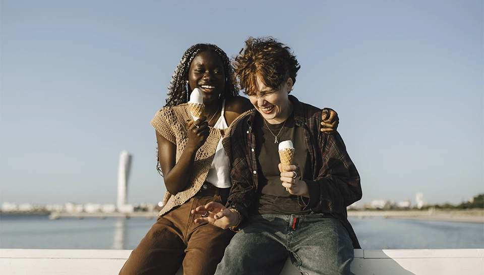 A customer being served at a till. the customer and till operator are smiling at each other