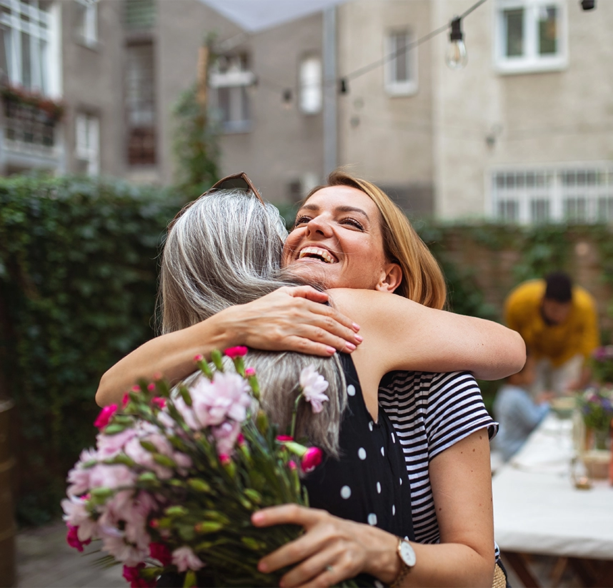 two people hugging with flowers